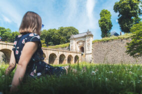 une personne étendue dans l'herbe devant les Fortifications de Longwy