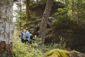 une famille en randonnée en forêt tenant une carte